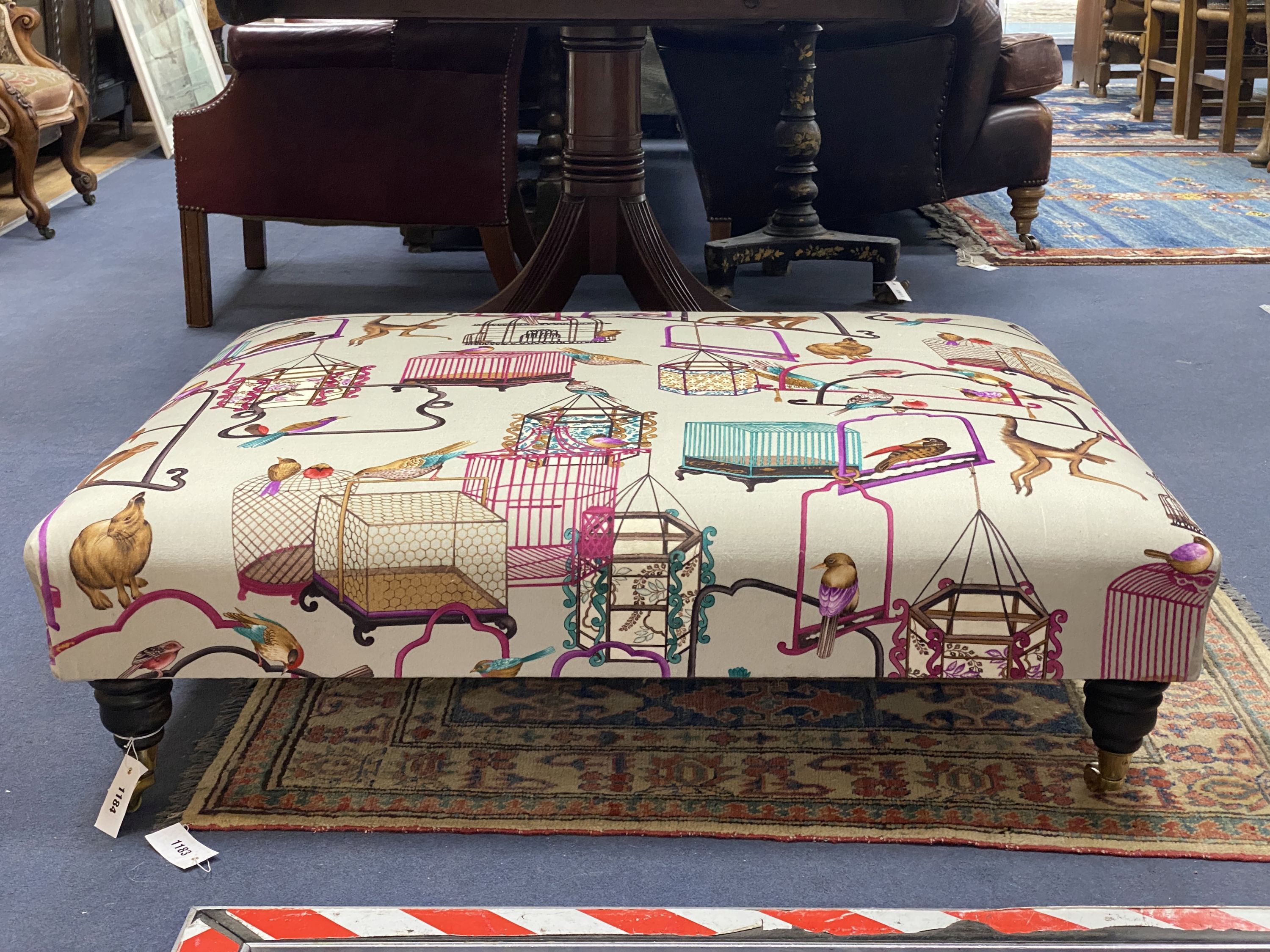A Victorian-style rectangular footstool, upholstered in menagerie fabric, width 106cm, height 90cm